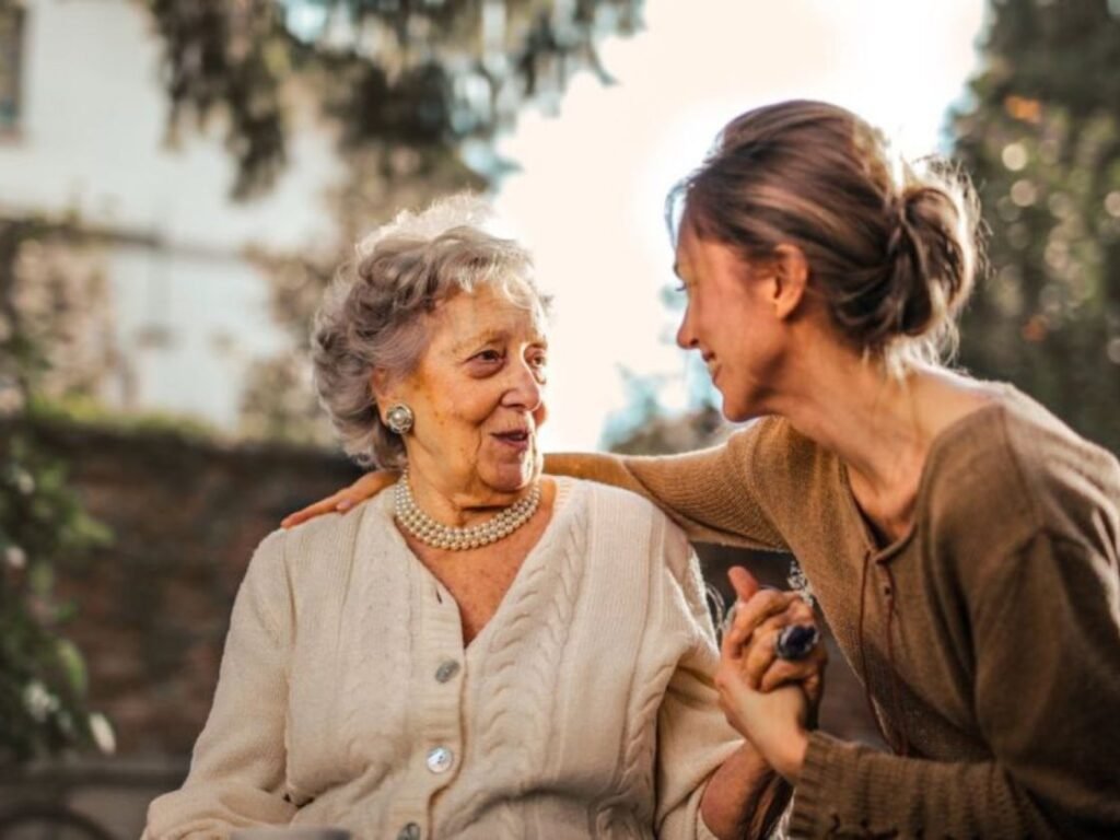 patient Home health nurse talking with elderly patient at home